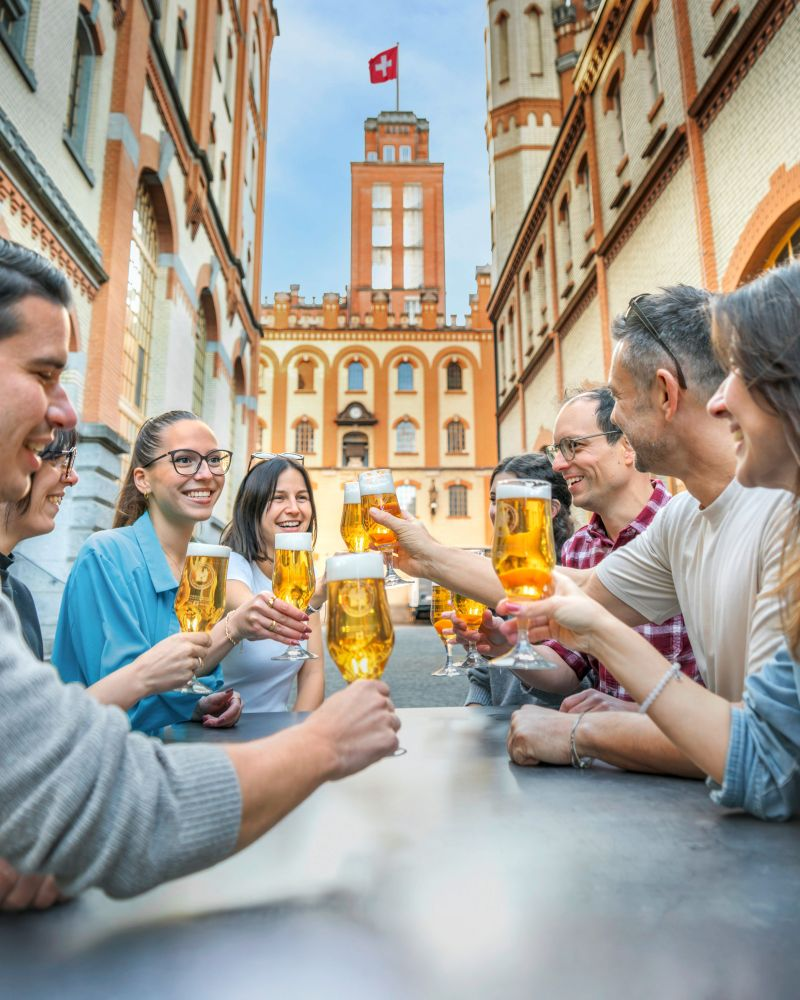 Mitarbeitende stossen vor dem Feldschlösschen Schloss mit Bier an